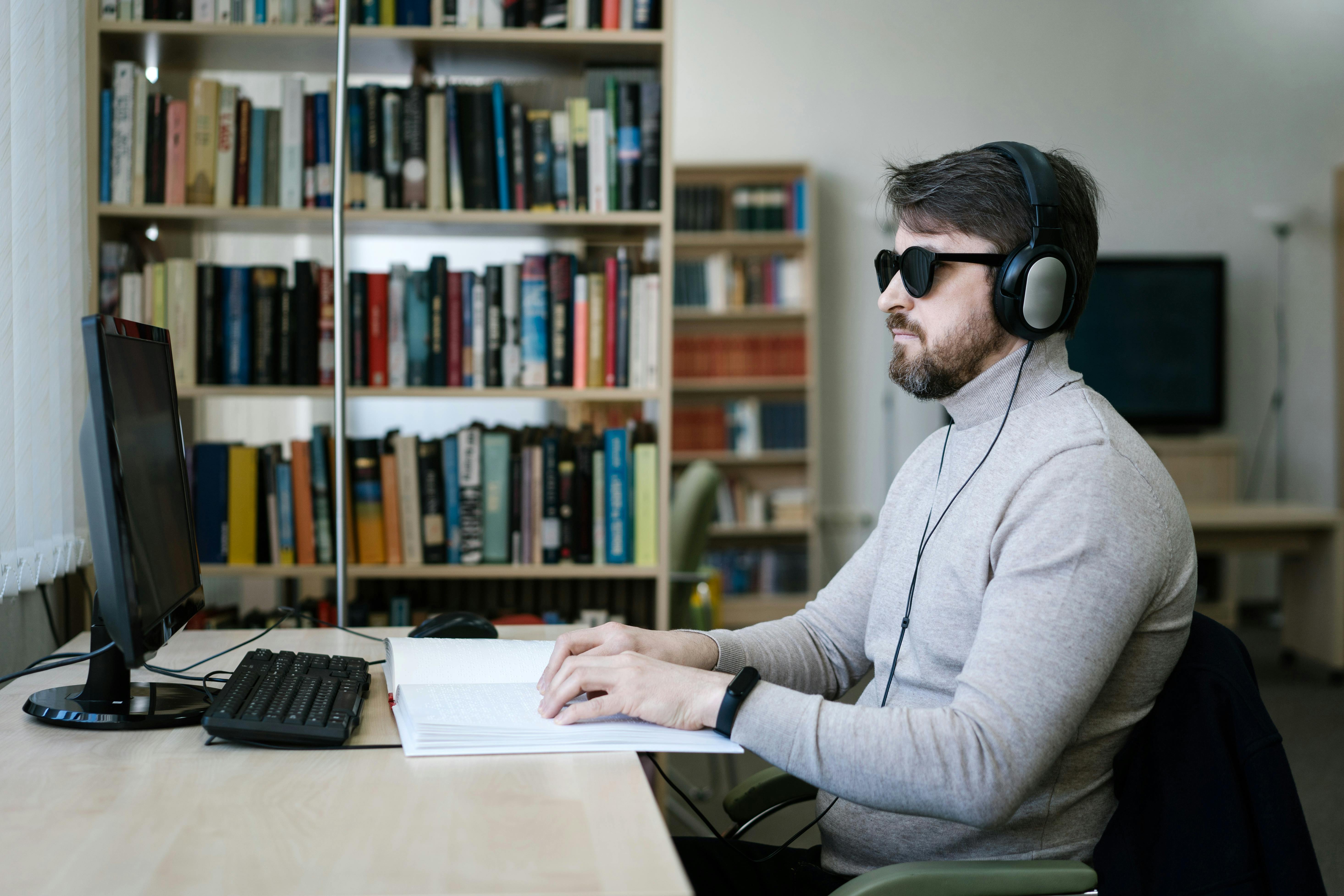 Un homme en situation de handicap visuel recourt à un dispositif d'accessibilité numérique. © Mikhail Nilov / Pexels