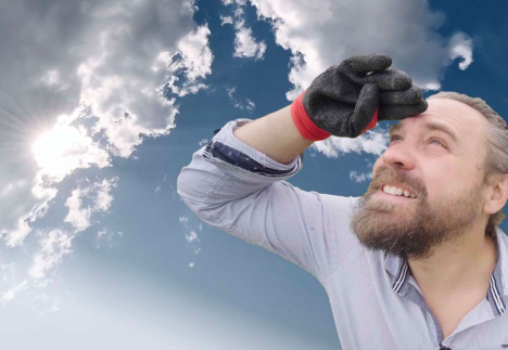 Un homme regarde vers le soleil avec la main en casquette