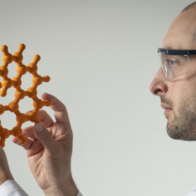 Homme regardant un modèle moléculaire fabriqué par impression 3D permettant de comprendre la stéréochimie.