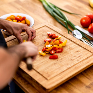 Personne de dos coupant des tomates