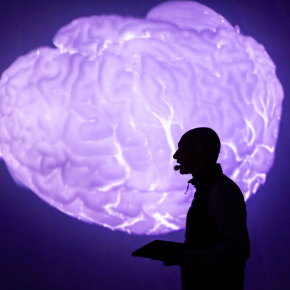 Silhouette d'un chercheur sur fond de cerveau luminescent